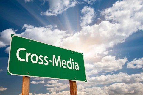 Cross-Media green road sign with dramatic clouds and sky