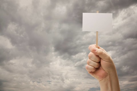 Man holding blank sign over dramatic storm cloudy sky