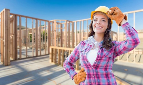 Young attractive female construction worker wearing gloves
