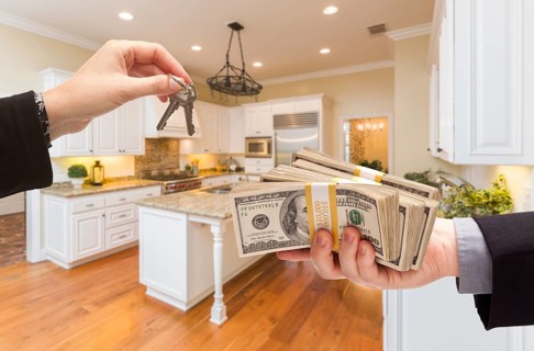 Handing over keys for cash in beautiful custom kitchen interior