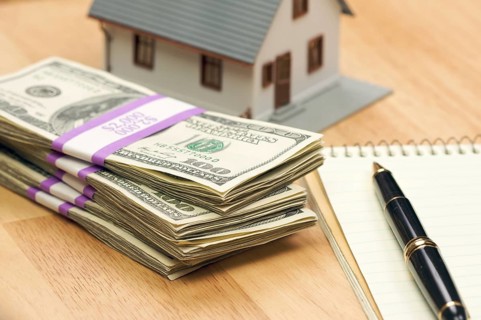 House and money with pad of paper and pen