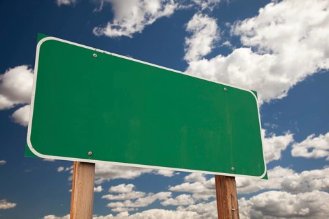 Blank green road sign on dramatic blue sky with clouds