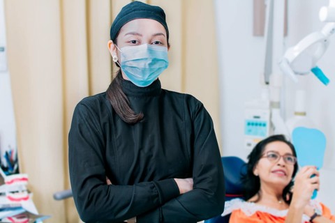 Dental doctor standing in clinic wearing mask