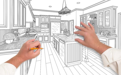 Male hands sketching with pencil the outline of a beautiful custom kitchen