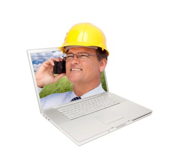 Laptop and man with hard hat on cell phone extruding the screen