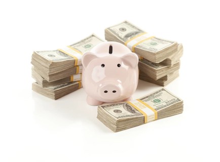 Pink piggy bank with stacks of hundreds of dollars isolated on a white background