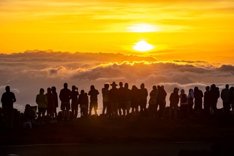 Touristen beobachten den Sonnenuntergang auf dem Gipfel des Haleakala Vulkan