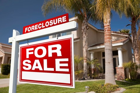 Foreclosure for sale real estate sign in front of house
