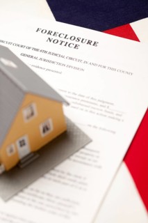 Foreclosure notice and house on the american flag with selective focus