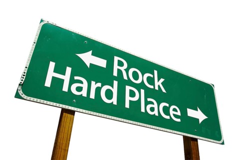 Rock and hard place green road sign isolated on a white background with clipping path