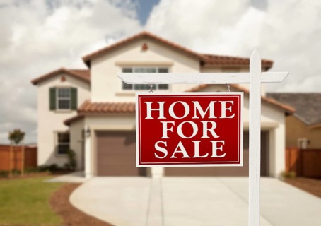 Home for sale real estate sign in front of new house