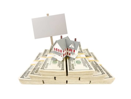 Small house on stacks of hundred dollar bills and blank sign isolated on a white background