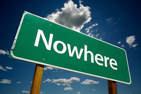 Nowhere green road sign against dramatic blue sky and clouds