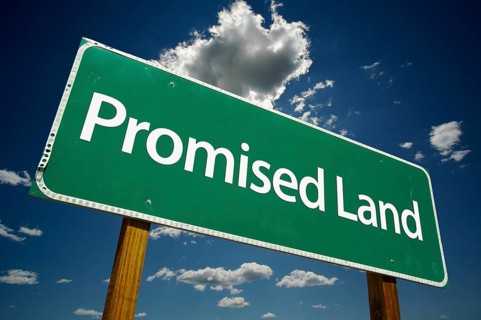 Promised land green road sign with dramatic clouds and sky