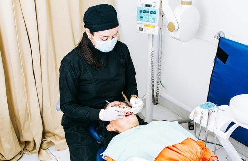 Woman dentist with patient lying down