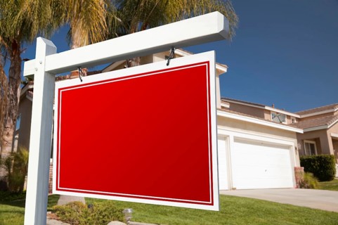 Blank real estate sign in front of house