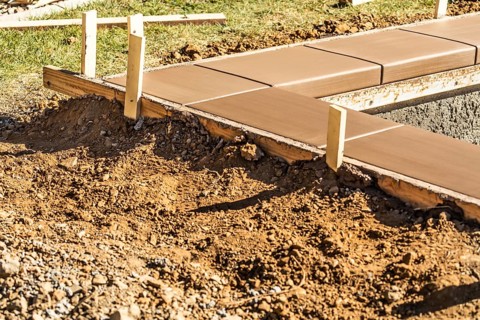 Fresh pool coping cement drying within wood framing