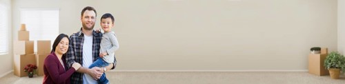 Banner of mixed-race chinese and caucasian parents and child inside empty room with moving boxes