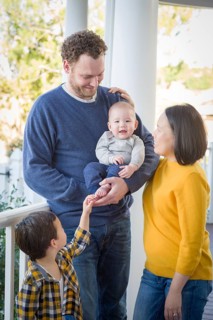 Young mixed-race chinese and caucasian family portrait on their front porch