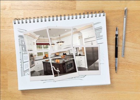 Sketch pad on desk with drawing of custom kitchen interior and photo frames showing finished construction next to engineering pencil and ruler