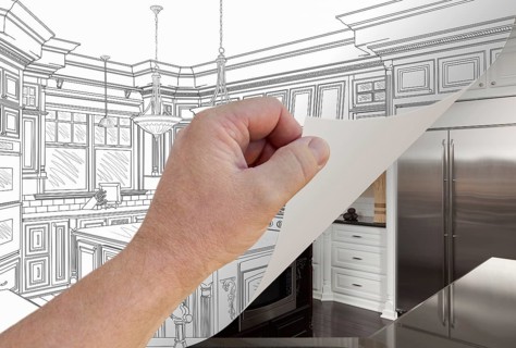 Male hand turning page of custom kitchen drawing to finished photograph underneath