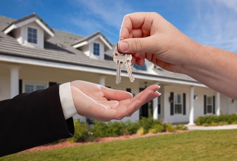 Handing over the house keys in front of a beautiful new home