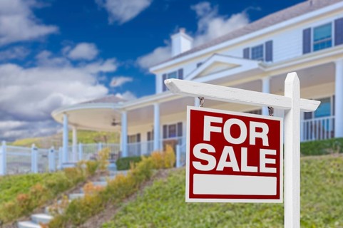 Home for sale real estate sign and beautiful new house