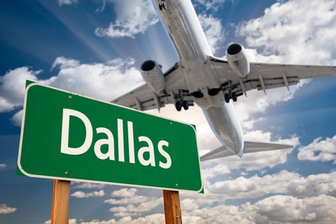 Dallas green road sign and airplane above with dramatic blue sky and clouds