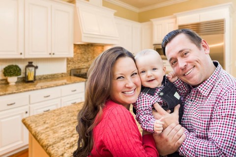 Young happy family inside beautiful custom kitchen