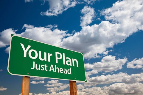 Your plan green road sign over dramatic clouds and sky
