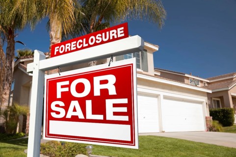 Foreclosure for sale real estate sign in front of house