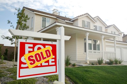 Sold home for sale real estate sign in front of new house