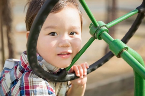 Adorable mixed-race young boy playing on the tractor at the pumpkin patch