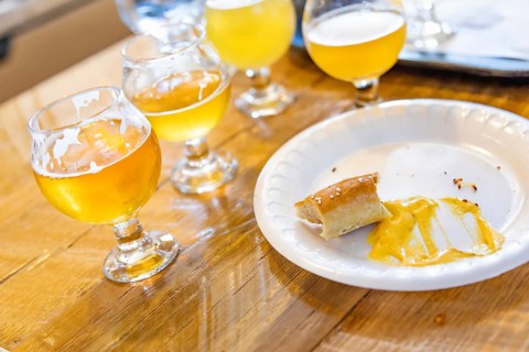 Abstract of small glass of micro brew beers and warm pretzels on bar