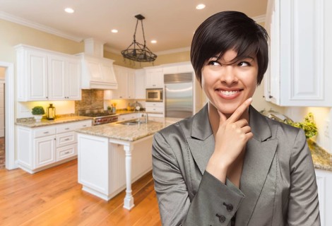 Pretty mixed-race woman looking back over shoulder inside custom kitchen interior