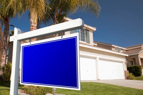 Blank real estate sign in front of house
