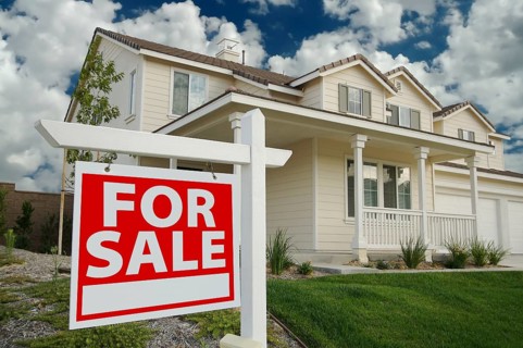 Home for sale sign in front of beautiful new home