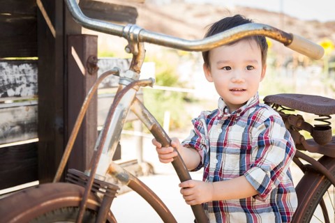Cute mixed-race young boy having fun on the bicycle