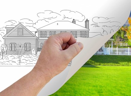 Male hand turning page of custom home photograph to drawing underneath