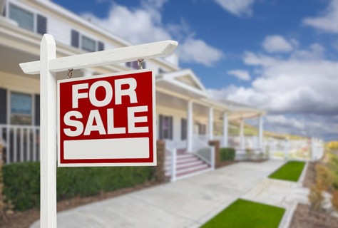 Home for sale real estate sign and beautiful new house