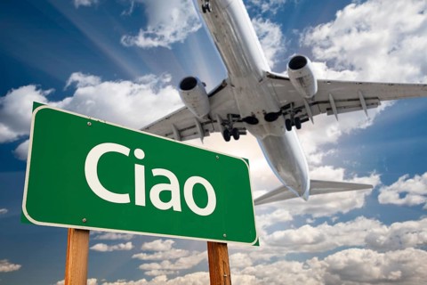 Ciao green road sign and airplane above with dramatic blue sky and clouds