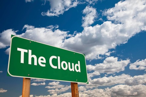 The cloud green road sign over clouds and sky