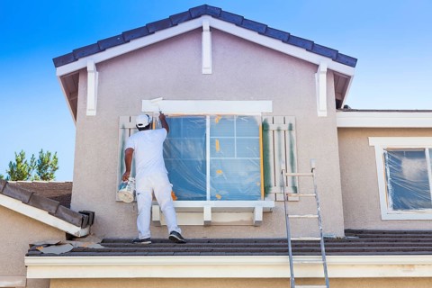 Busy house painter painting the trim and shutters of A home