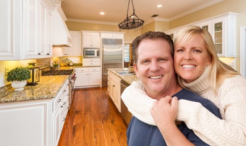 Happy couple hugging inside beautiful custom kitchen