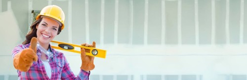 Female contractor wearing hard hat against dywall banner background with ladder