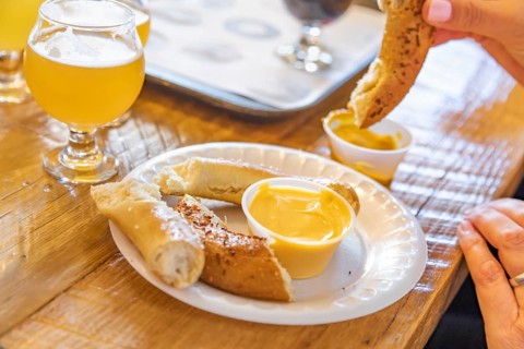 Woman enjoys warm pretzels and micro brew beer
