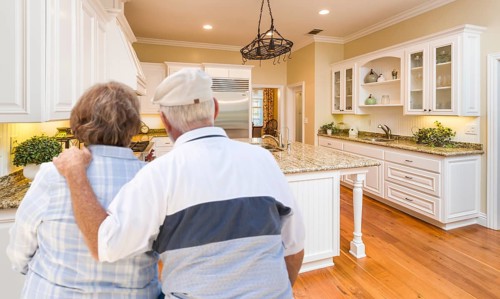 Happy senior couple looking over beautiful custom kitchen design