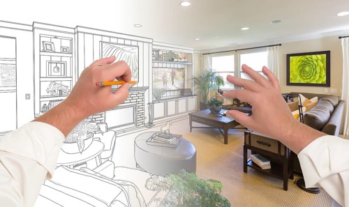 Male hands drawing custom living room design gradating into photograph