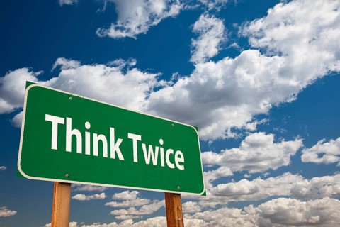 Think twice green road sign over clouds and sky
