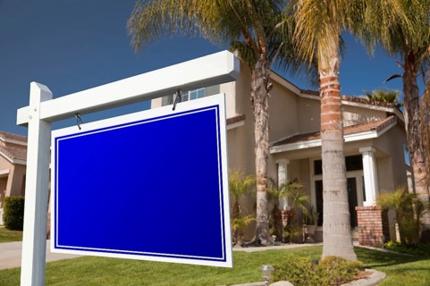 Blank real estate sign in front of house